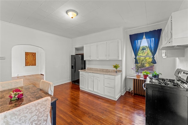 kitchen featuring black appliances, radiator, dark hardwood / wood-style floors, and white cabinets