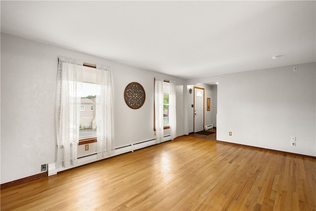 empty room featuring light wood-type flooring and baseboard heating