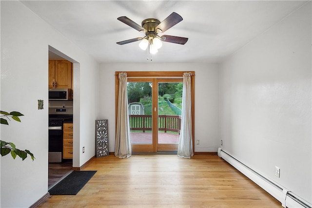 interior space featuring light wood-type flooring, baseboard heating, and ceiling fan