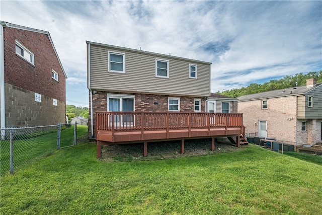 rear view of property featuring a lawn and a wooden deck