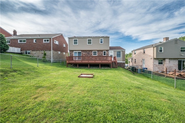 back of property with a lawn and a wooden deck