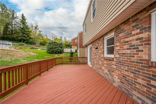 wooden deck featuring a lawn