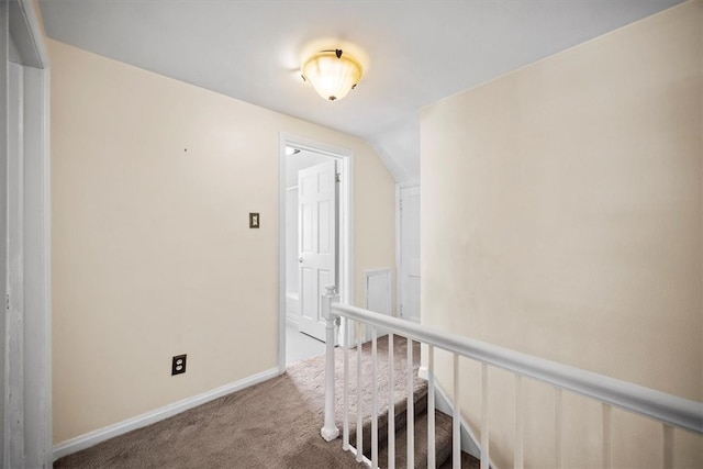 corridor featuring carpet flooring and vaulted ceiling