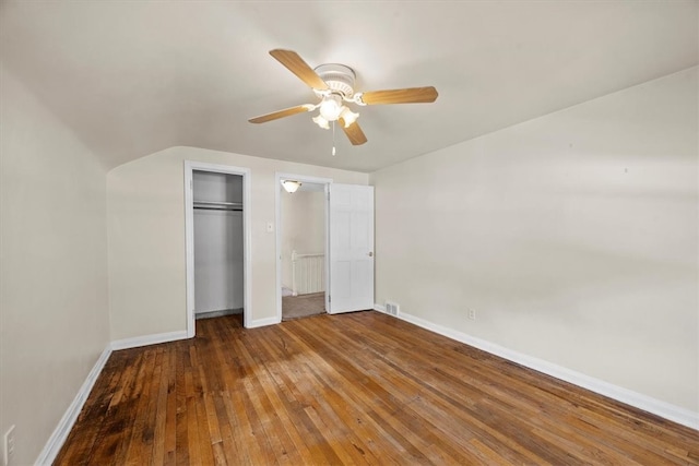 unfurnished bedroom with hardwood / wood-style flooring, ceiling fan, radiator heating unit, and vaulted ceiling