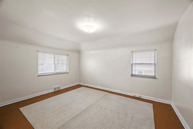 empty room with dark hardwood / wood-style flooring