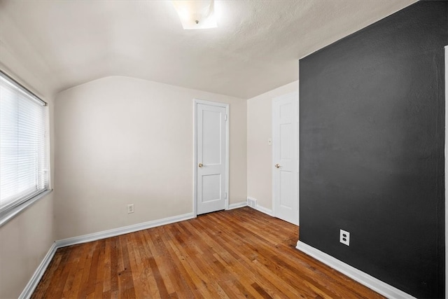 interior space featuring hardwood / wood-style flooring and lofted ceiling