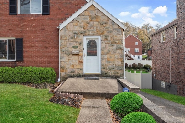 property entrance with a lawn