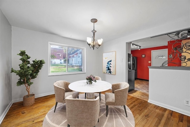 dining area with light wood-type flooring and a chandelier