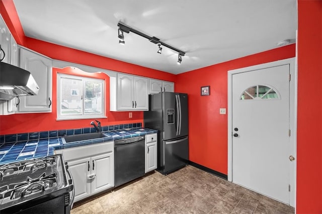 kitchen with tile countertops, black appliances, sink, and white cabinets