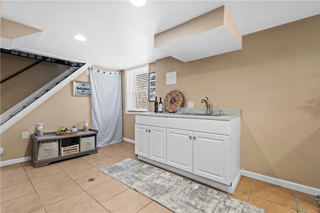 interior space with white cabinetry, light tile patterned floors, and sink