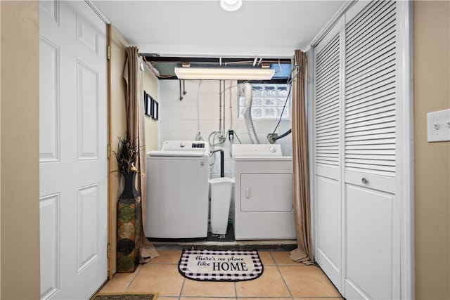 laundry area featuring washing machine and clothes dryer and light tile patterned floors