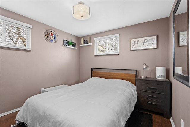 bedroom with dark hardwood / wood-style flooring