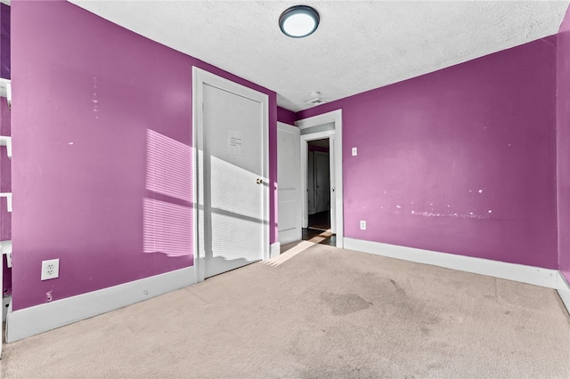 unfurnished bedroom with a textured ceiling and carpet floors