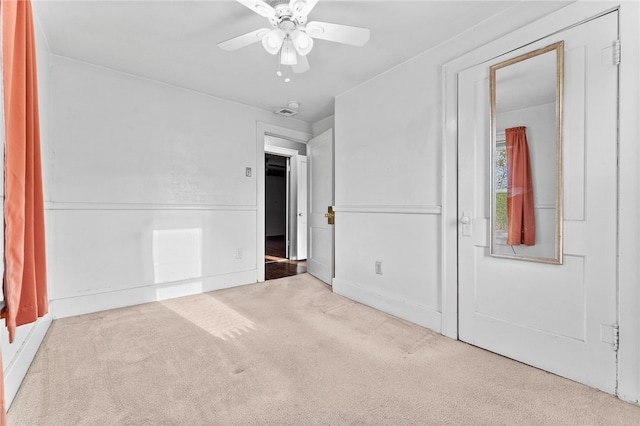 unfurnished room with ceiling fan and light carpet