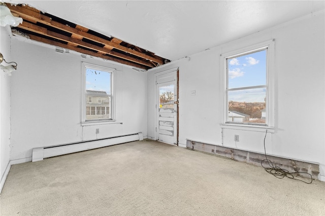 unfurnished room with light carpet, beam ceiling, and a baseboard heating unit