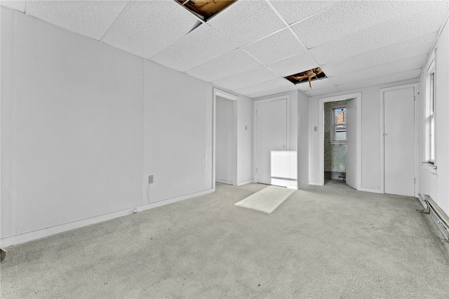 spare room with a drop ceiling and light colored carpet