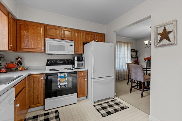 kitchen featuring pendant lighting, an inviting chandelier, sink, white appliances, and light colored carpet