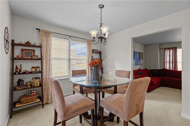 dining area with light colored carpet and a notable chandelier