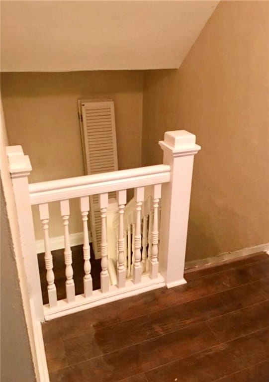 stairway featuring hardwood / wood-style flooring and vaulted ceiling