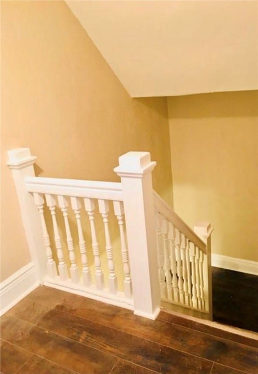 stairs with lofted ceiling and hardwood / wood-style floors