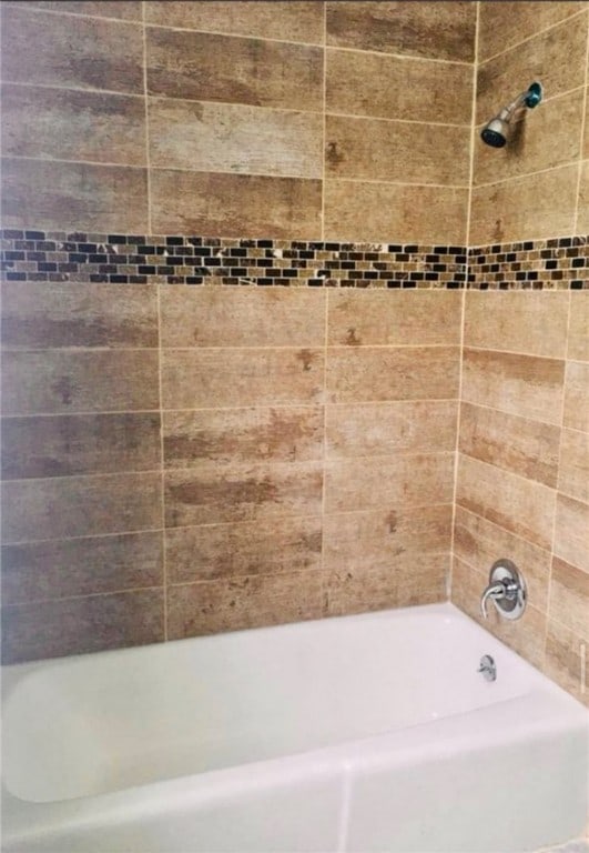 bathroom featuring tiled shower / bath