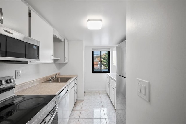 kitchen with white cabinetry, appliances with stainless steel finishes, sink, and light tile patterned floors