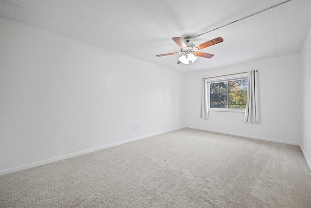 carpeted spare room featuring ceiling fan and a textured ceiling