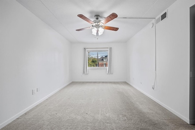 carpeted spare room with a textured ceiling and ceiling fan