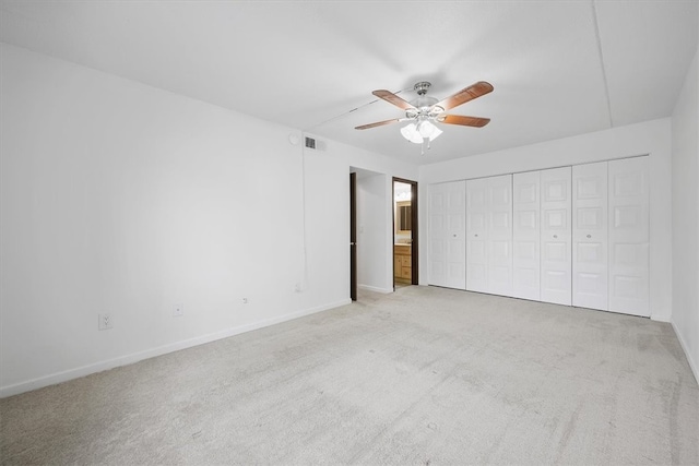 unfurnished bedroom featuring ceiling fan, light carpet, and a closet