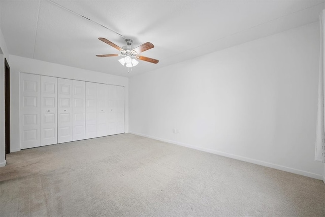 unfurnished bedroom featuring ceiling fan, a closet, and carpet floors