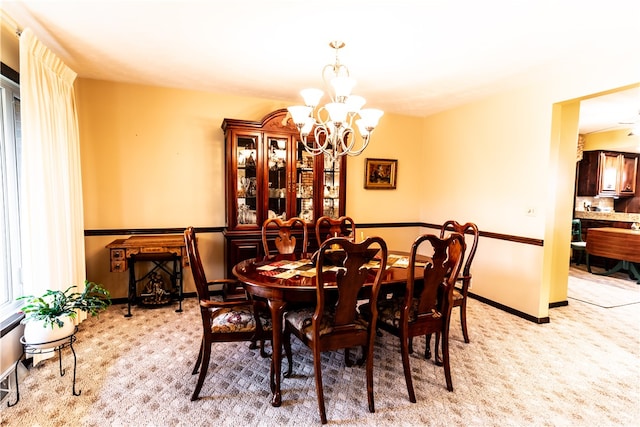 carpeted dining room featuring a notable chandelier