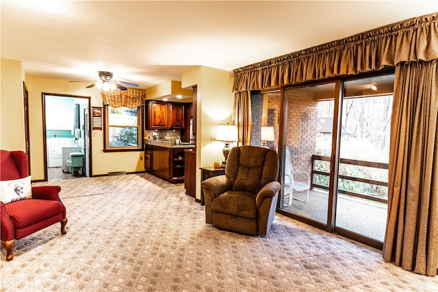 sitting room with ceiling fan, light carpet, and washer / clothes dryer