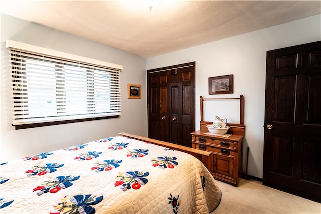 bedroom featuring light carpet and a closet