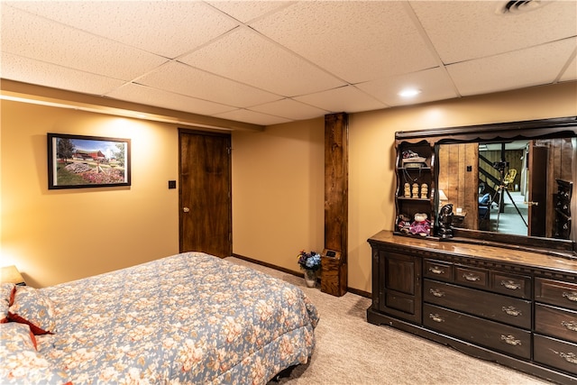 bedroom with light colored carpet and a paneled ceiling