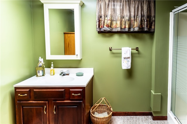 bathroom featuring vanity and a shower with door