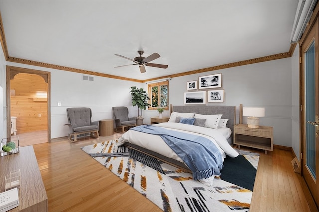 bedroom featuring hardwood / wood-style floors, ceiling fan, and crown molding