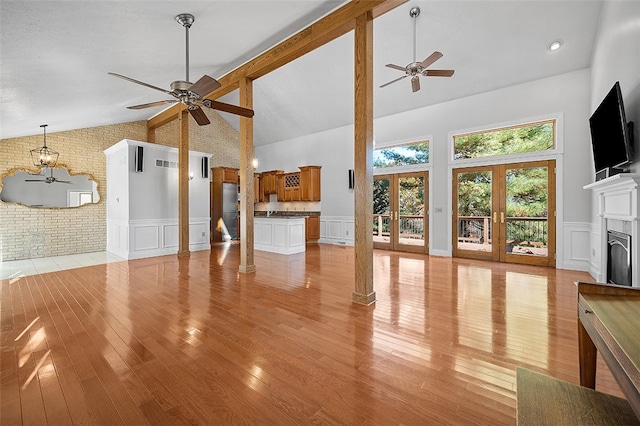 living room with french doors, light hardwood / wood-style floors, ceiling fan, and high vaulted ceiling