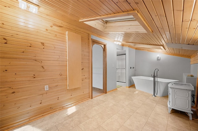 interior space featuring tile patterned floors, wood ceiling, wooden walls, and a bathtub