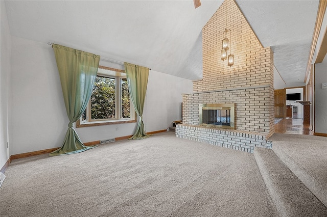 unfurnished living room with a fireplace, lofted ceiling, a textured ceiling, and carpet floors