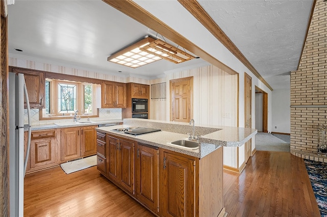 kitchen featuring white refrigerator, sink, a center island with sink, and crown molding