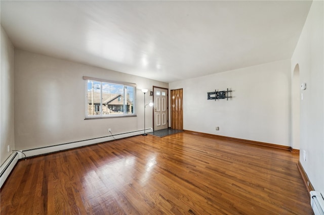 spare room with hardwood / wood-style floors and a baseboard radiator