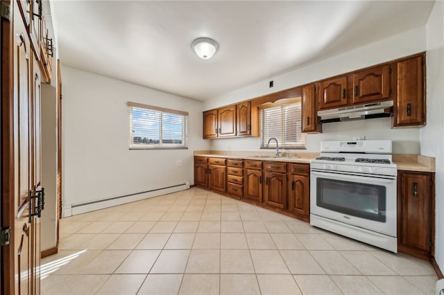 kitchen with light tile patterned flooring, sink, baseboard heating, and white gas stove