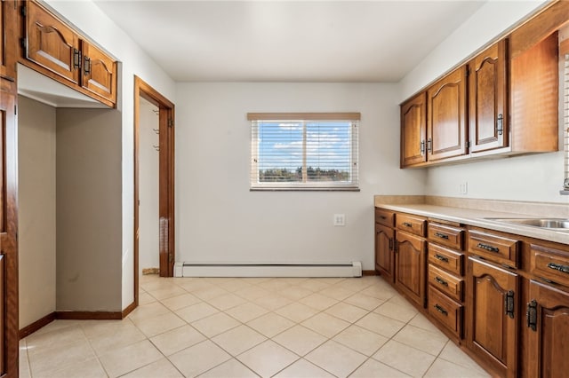 kitchen featuring light tile patterned floors, a baseboard radiator, and sink