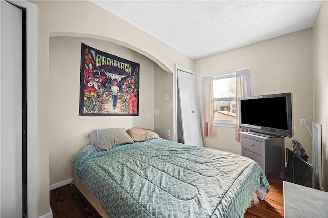 bedroom featuring wood-type flooring, a textured ceiling, and a closet