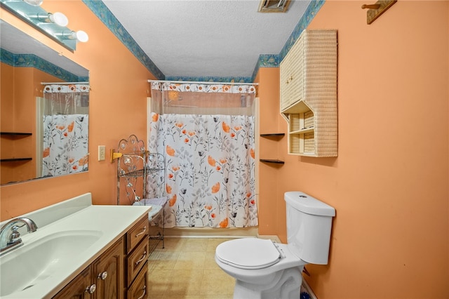 full bathroom with tile patterned floors, vanity, a textured ceiling, toilet, and shower / bath combo with shower curtain