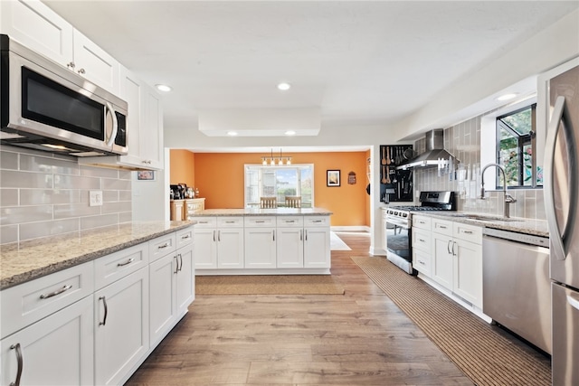 kitchen with white cabinets, a healthy amount of sunlight, light hardwood / wood-style flooring, and appliances with stainless steel finishes