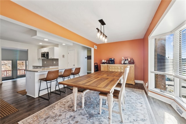 dining area with dark wood-type flooring and plenty of natural light