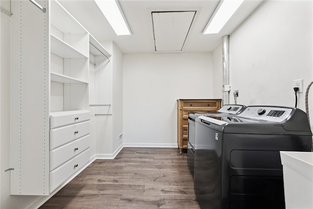 laundry room featuring wood-type flooring, washer and clothes dryer, and sink