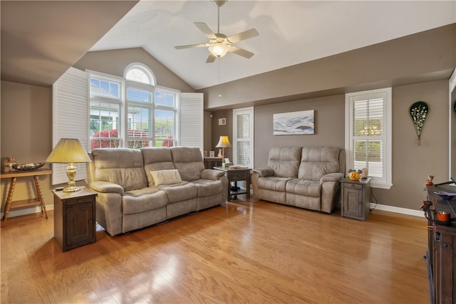 living room with light hardwood / wood-style floors, ceiling fan, lofted ceiling, and a healthy amount of sunlight