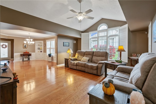 living room with built in shelves, lofted ceiling, ceiling fan with notable chandelier, and light hardwood / wood-style flooring